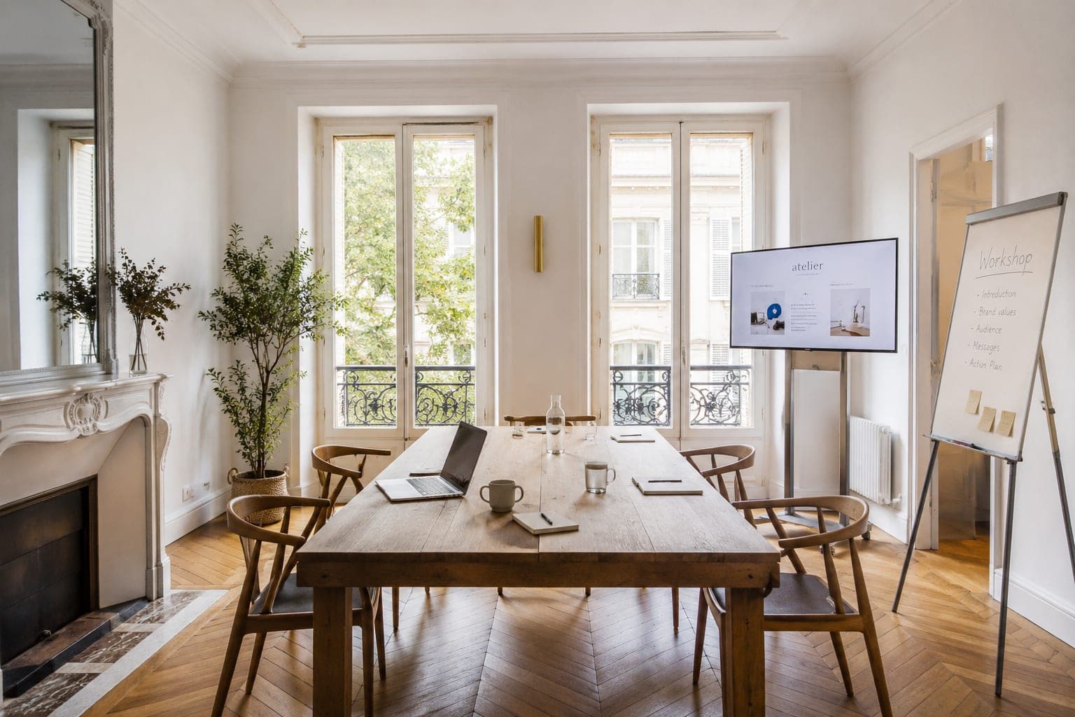 Appartement parisien aménagé en salle de séminaire, grande table et écran de présentation